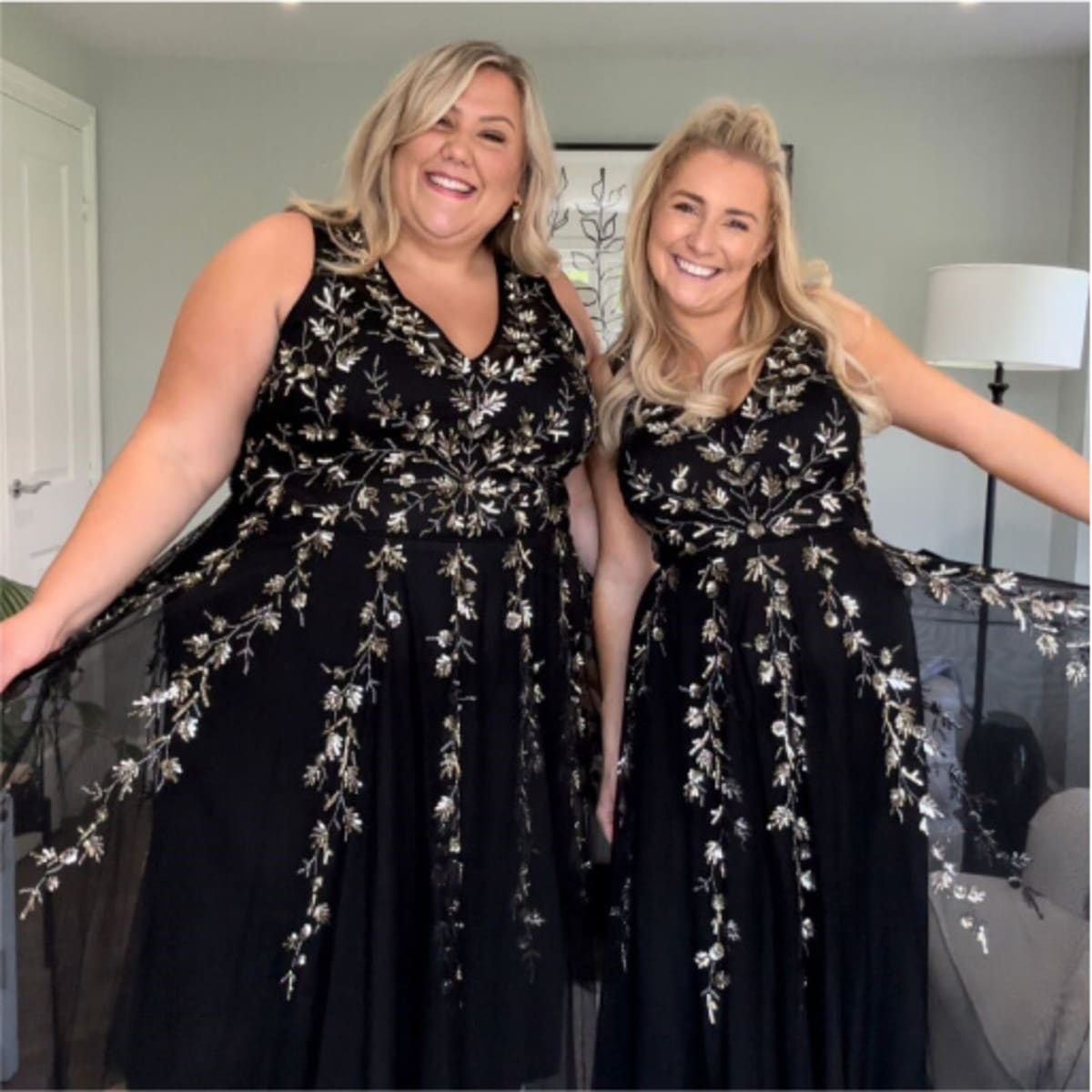 Two women in black floral patterned evening dresses