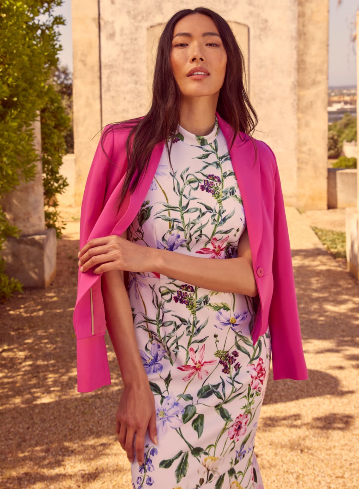 Woman wearing floral dress and pink jacket