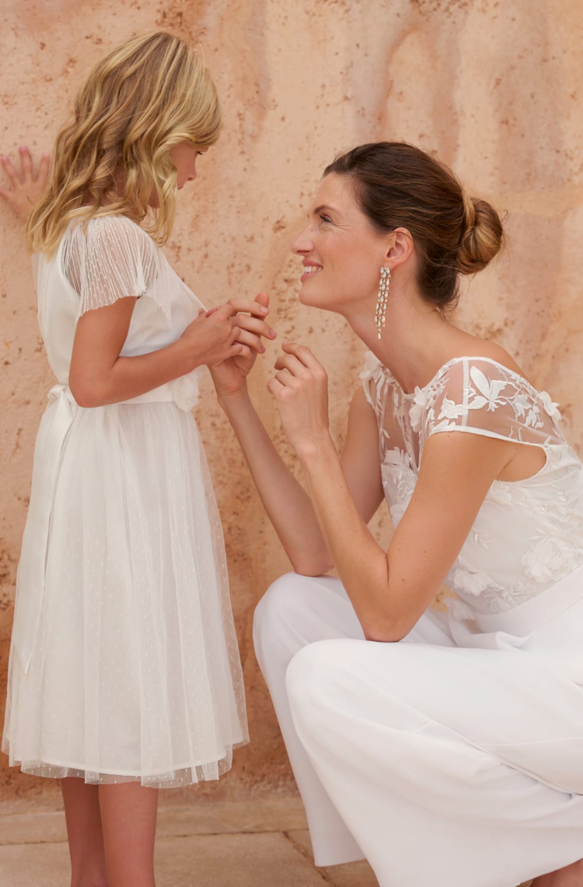 Child wearing Phase Eight Childrenswear Flower Girl Dress with woman wearing Phase Eight Bridal Jumpsuit