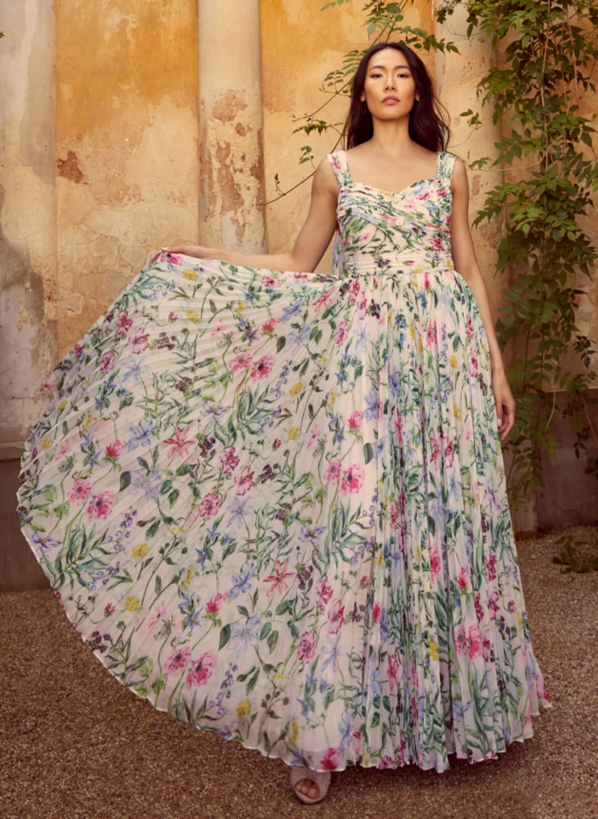 Woman wearing floral maxi occasion dress with pleated skirt