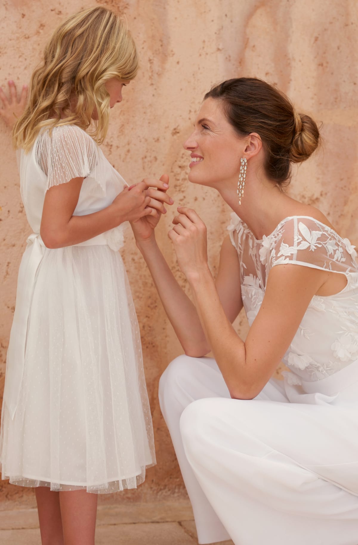 Woman wearing Phase Eight Cherie Bridal Jumpsuit with flower girl