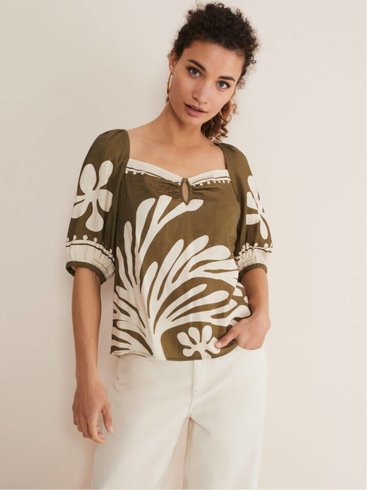 Woman wearing placement print linen top and white trousers