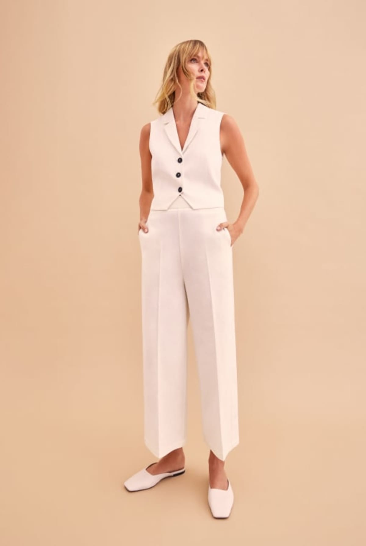 Woman modelling white suit trousers and waistcoat