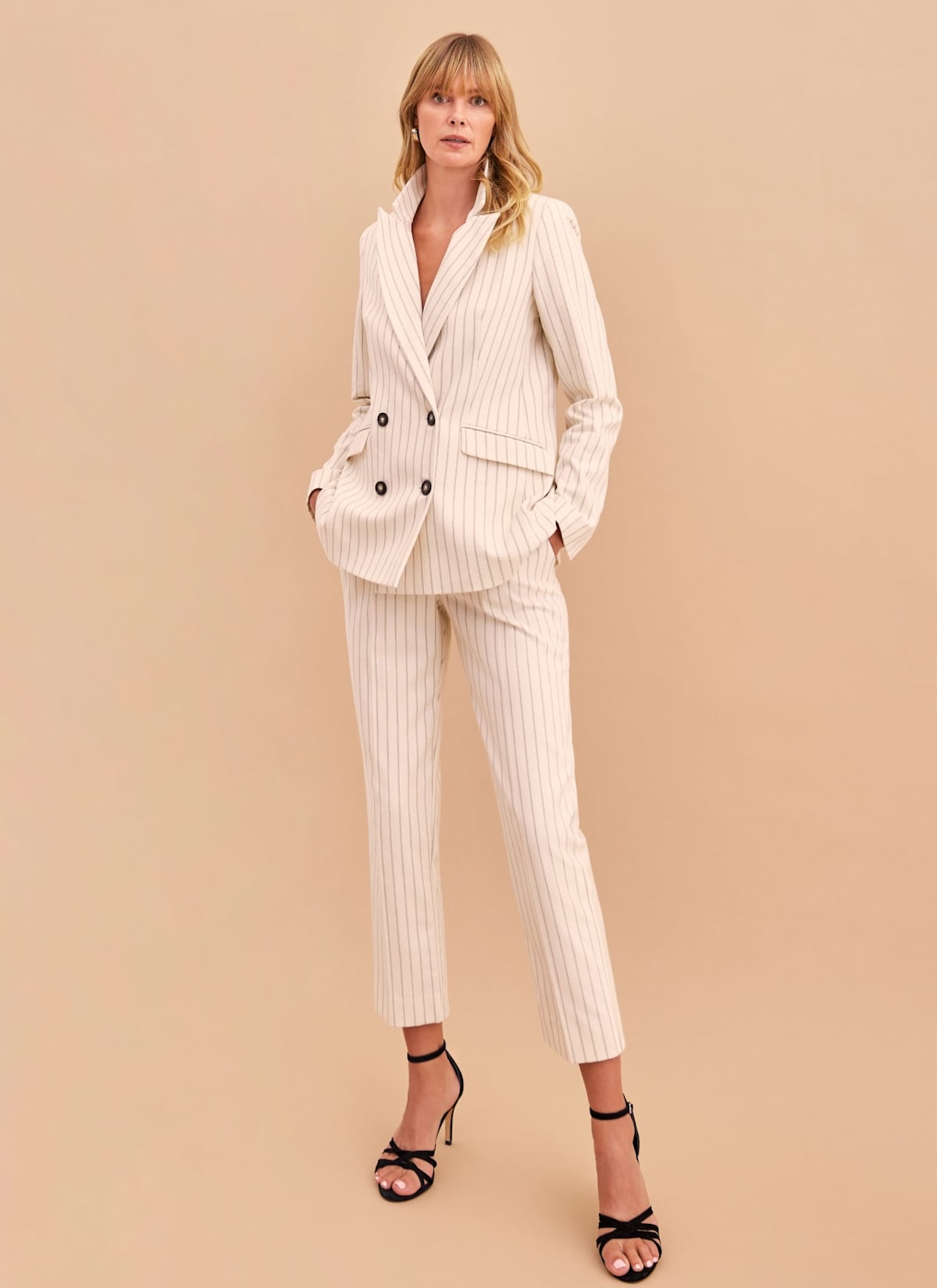 Woman modelling striped blazer with striped suit trousers and black heels