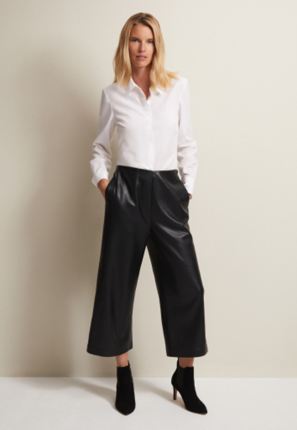 Woman in Phase Eight white shirt and faux leather trousers