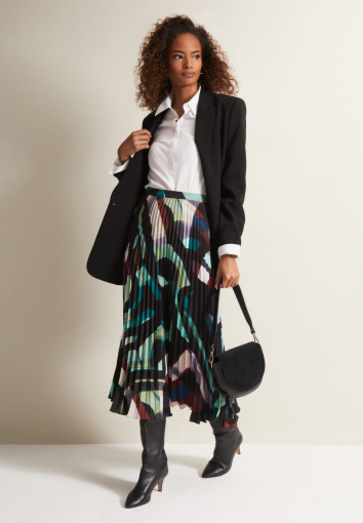 Woman in Phase Eight printed skirt, black blazer and white shirt