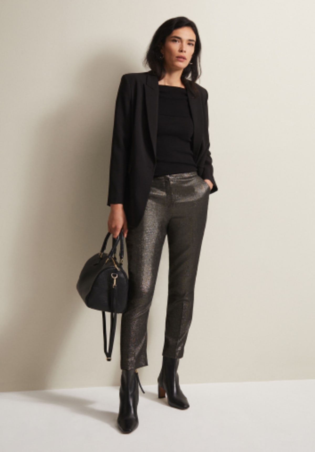 Woman in Phase Eight black blazer and metallic trousers