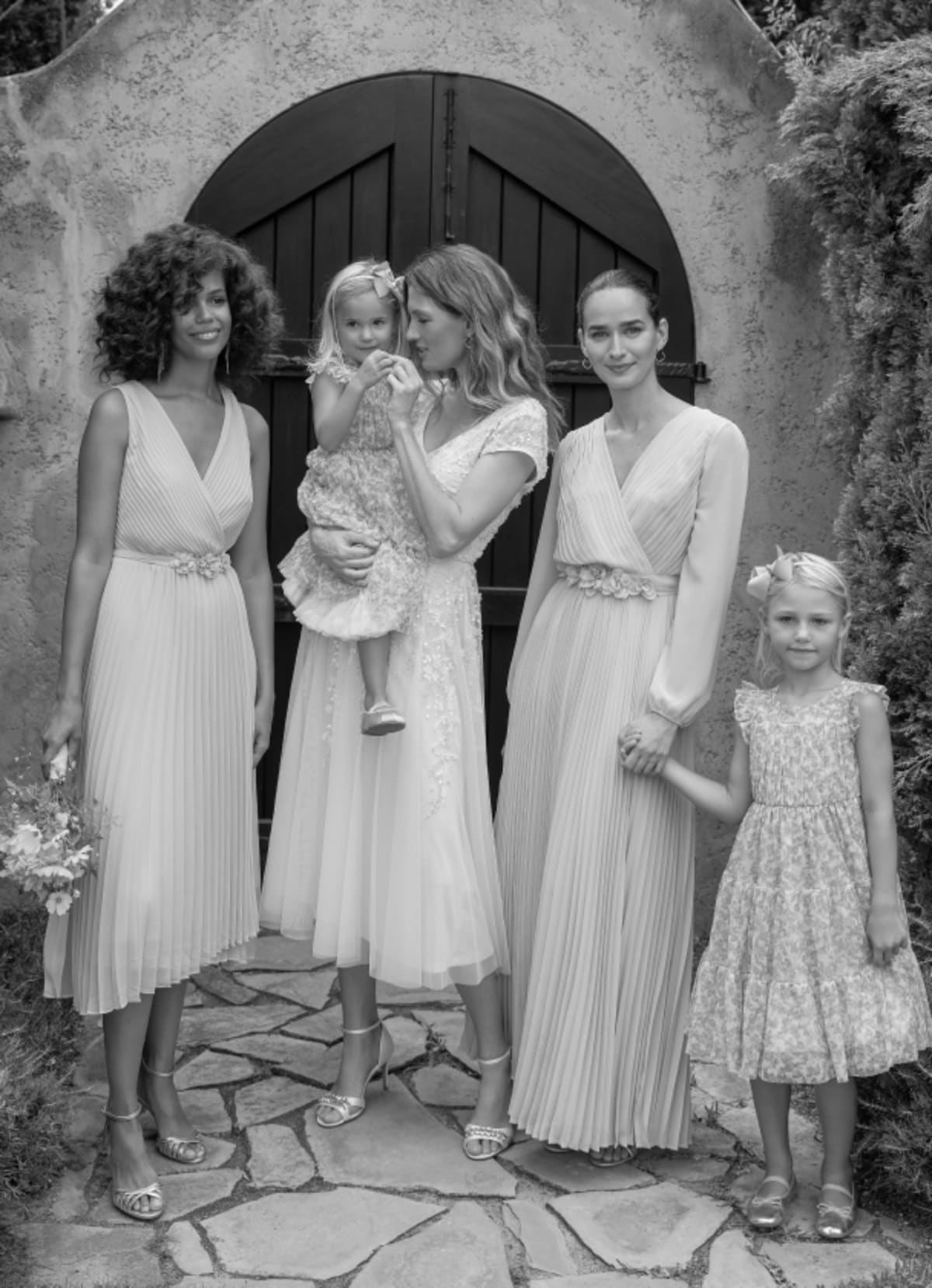 Woman wearing Phase Eight wedding dress with women wearing bridesmaid dresses and girls wearing flower girl dresses