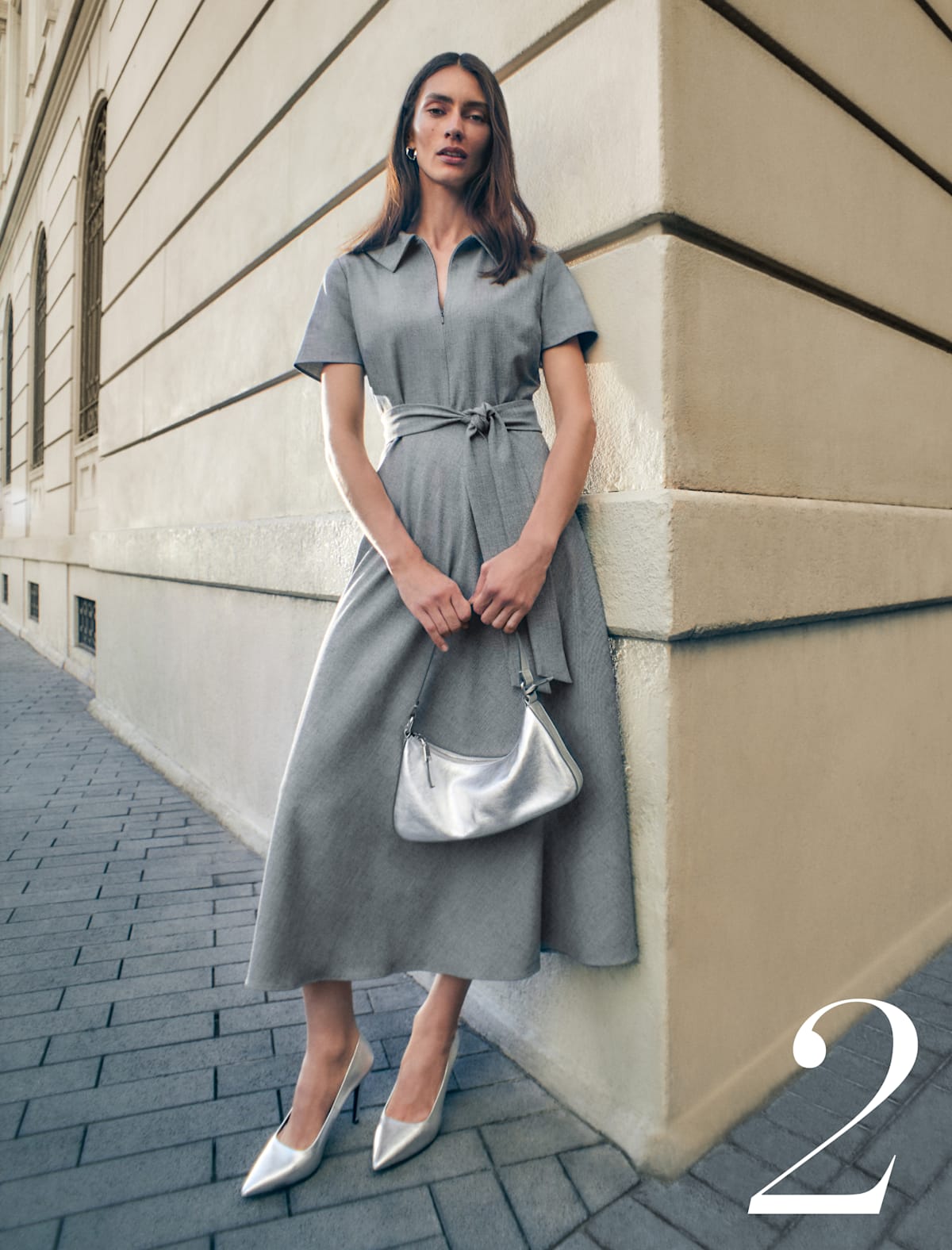 Woman wearing Phase Eight grey dress with silver handbag and heels